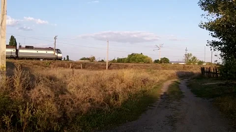 Train rides on the background of dry grass and village roads Stock Footage 50374165