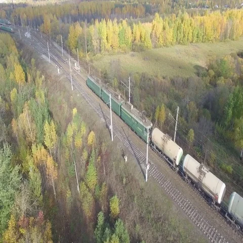 Train rides through an autumn forest on the horizon you can see the city. 動画素材 69637231