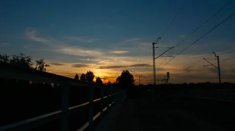 Train rides on tracks during sunset. Timelaps. 4k Stock Footage 61093577