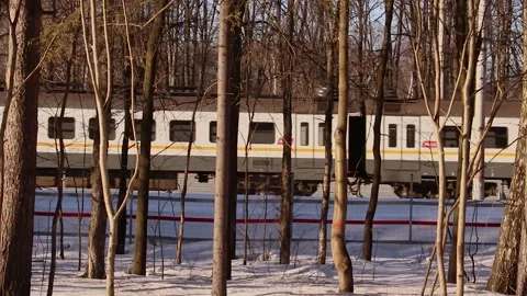 A train rides on a winter road in sunny weather at sunset Stock Footage 172417152