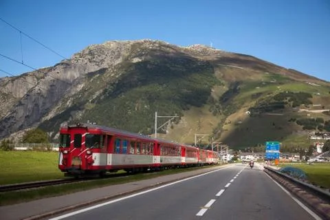Train running parallel to road, Gotthard Pass, Ticino, Switzerland Stock Photos