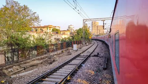 Train running on railway track with flat sky at morning from different angle Stock Photos