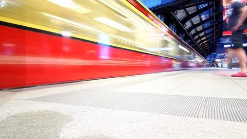 Train running throug a station mit motion blurr Stock Photos