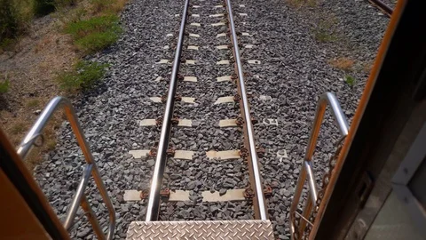 Train running on track on a railway or railroad in summer time Видео 104822879