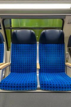 Train seats by window in empty carriage. Transport travel concept. Stock Photos
