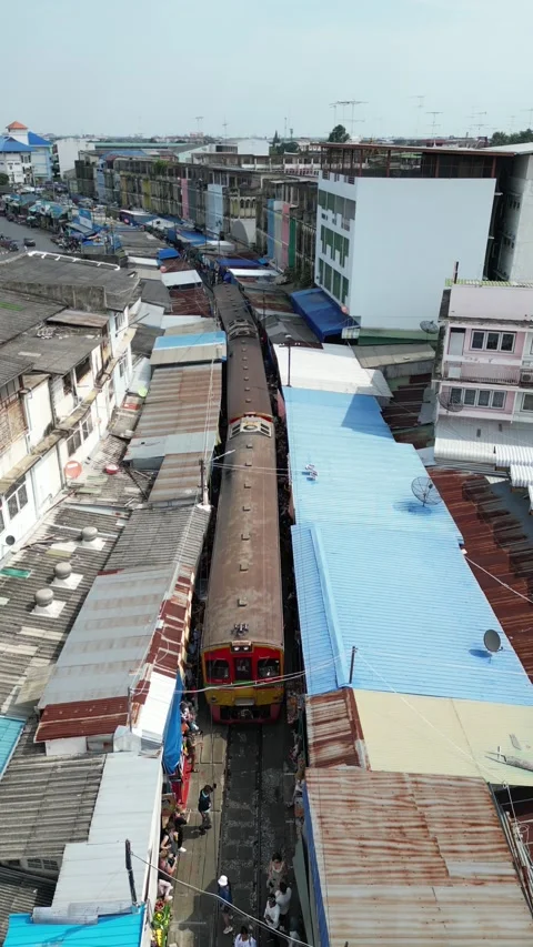 Train Slowly Passing Through Maeklong Railway Market in Samut Songkhram, Stock Footage 335588661