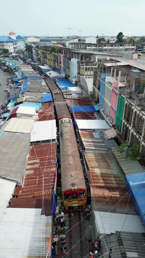 Train Slowly Passing Through Maeklong Railway Market in Samut Songkhram, Video stock 335588700
