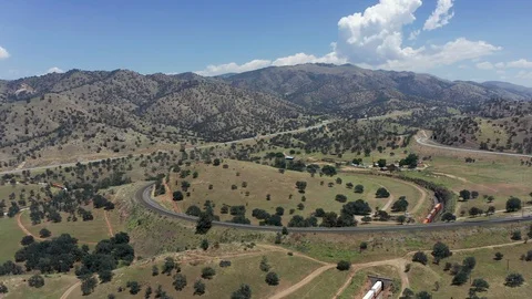 Train slowly passing through Tehachapi Loop, Aerial Birds Eye View Stock Footage 112145835