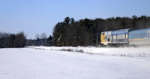 Train speeds down train track on sunny winter day Stock Footage 148223128