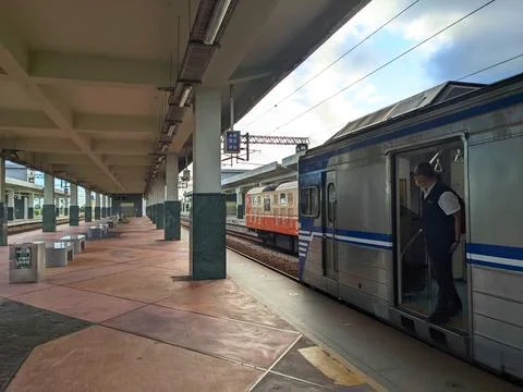 A train staff checking the empty platform from the train carriage before Stock Photos