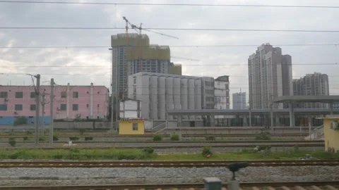 The train starts and leaves the station of a city under construction, in China Stock Footage 232201447