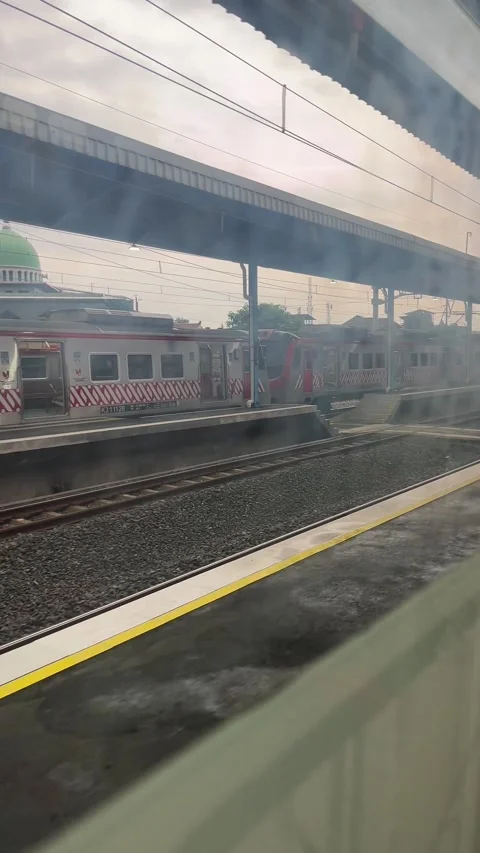 Train at the station from behind the window of a moving train Stock Footage 296452302
