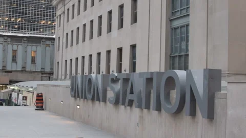 Train station commuters walking past Union Station sign Toronto Video stock 246711960