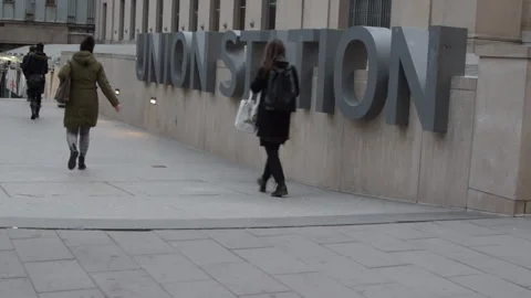 Train station commuters walking past Union Station sign Toronto Video stock 246711969