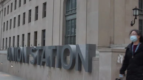 Train station commuters walking past Union Station sign Toronto Video stock 246712090