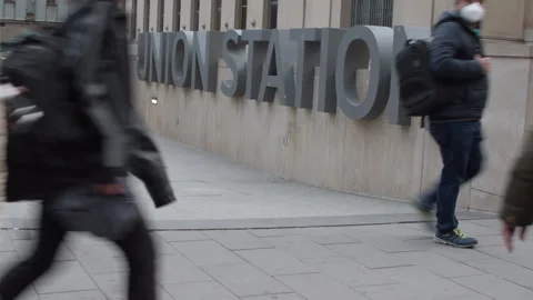Train station commuters walking past Union Station sign Toronto Video stock 246712240