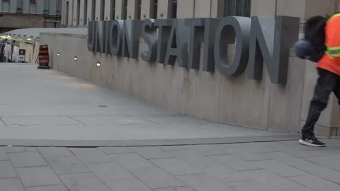 Train station commuters walking past Union Station sign Toronto Video stock 246712241