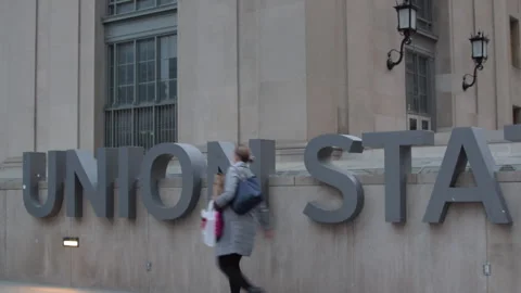 Train station commuters walking past Union Station sign Toronto Video stock 246712261
