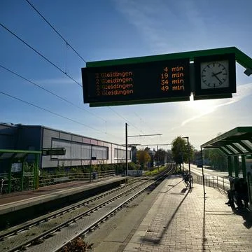 A Train Station that features a Schedule Display and a prominently placed Clock Stock Photos