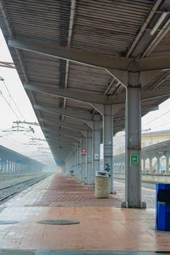Train station platform in fog with empty tracks and gray sky in the early m.. Foto stock