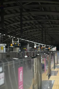 Train Station Platform View with Overhead Lighting and Metal Structure. Stock Photos
