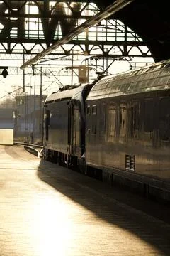 Train at station platform in warm evening light Stock Photos