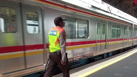 Train station security officer walking along the train platform Stock Footage 157086615