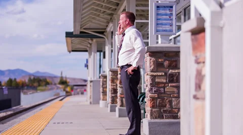 Train station walking and talking on cell phone Stock Footage 32243353