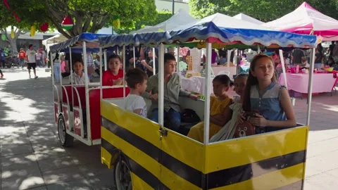 A train of strolling children in the center square at the ice cream Stock Footage 246562528
