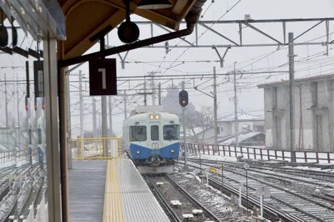 Train through the snow into a platform Stock Photos