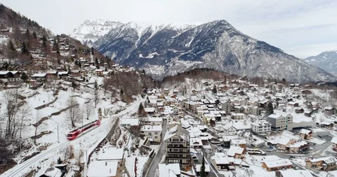 Train TMR pass in Salvan snow fall - Aerial 4K Stock Footage 104600101