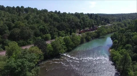 Train on track beside river Stock Footage 68137460