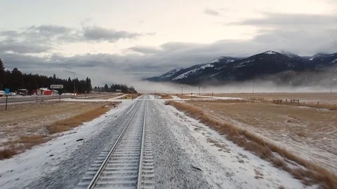 Train track in snow next to dirt road Stock Footage 124927192
