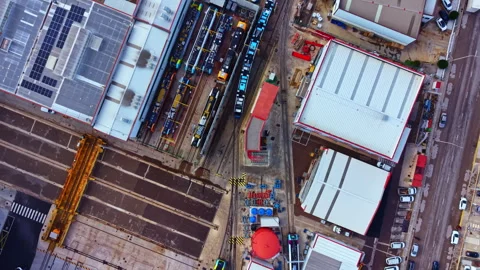 Train tracks and warehouse area in an industrial location with multiple vehicles Stock Footage 335368428