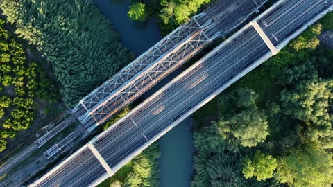 Train tracks go over river through a truss bridge Stock Footage 258303200