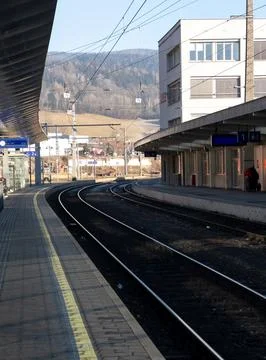 Train tracks going into the distance from the platform of a train station Stock Photos