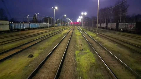 Train tracks illuminated by overhead lights at dusk, showcasing a gradual camera Stock-Footage 329964606