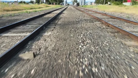 Train Tracks Low Drone Shot Summer Out West Idaho Grain Silo in Background Stock Footage 154142842
