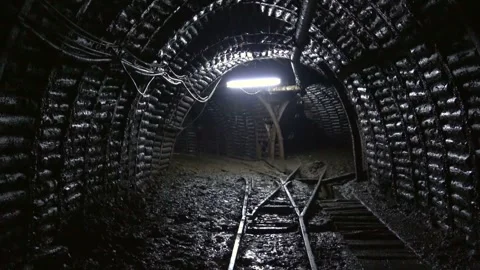 Train tracks pass through wet underground mining corridor - Dark and Employment Stock Footage 339585848