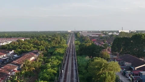 Train tracks run through a lush residential area Vídeo Stock 329355112