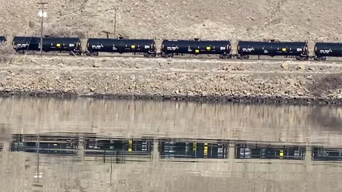 A train transporting oil is reflected into the Columbia River. Stock Footage 146145436