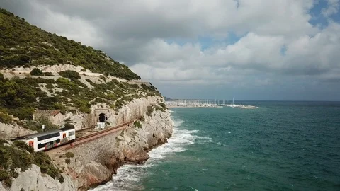 Train traveling though the coastal hillside of Costa Brava, Spain Stock Footage