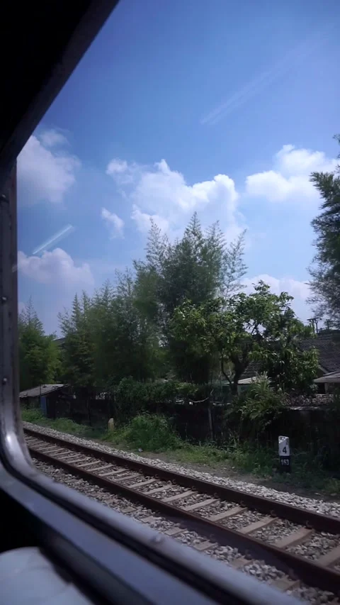 Train view from the train window with lush green trees and calm cloudy sky. Stock Footage 332855772