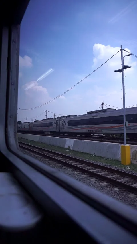 Train view from the train window with lush green trees and calm cloudy sky. Video stock 332855775