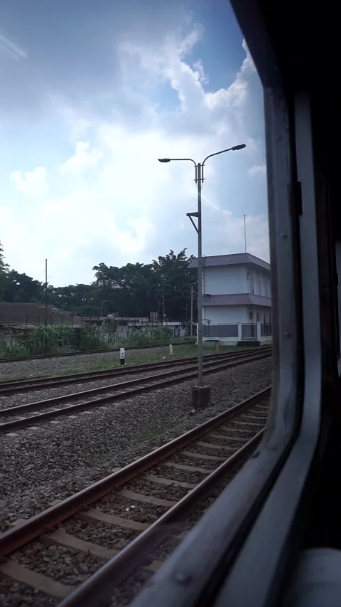 Train view from the train window with lush green trees and calm cloudy sky. Stock Footage 332855780