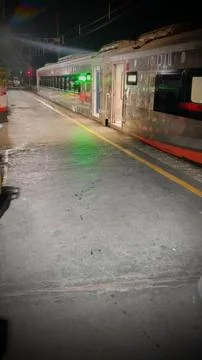 Train Waiting at Night Station Platform with Green Light Reflection Stock Photos