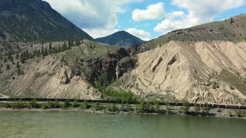 Train with waterfall and river, Drone shot Stock Footage 289576781