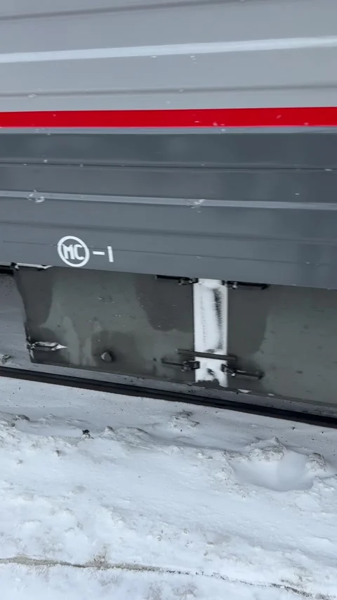 Train wheels rolling onto a snowy station platform, creating tracks as the tr Vídeos de archivo 302471441