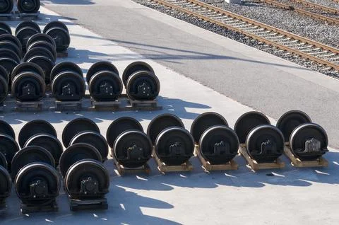 Train wheelsets stored in row outside railway maintenance facility near track Stock Photos