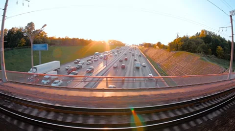 In the train window can seen the highway with cars and sun with beautiful rays Video stock 61059099